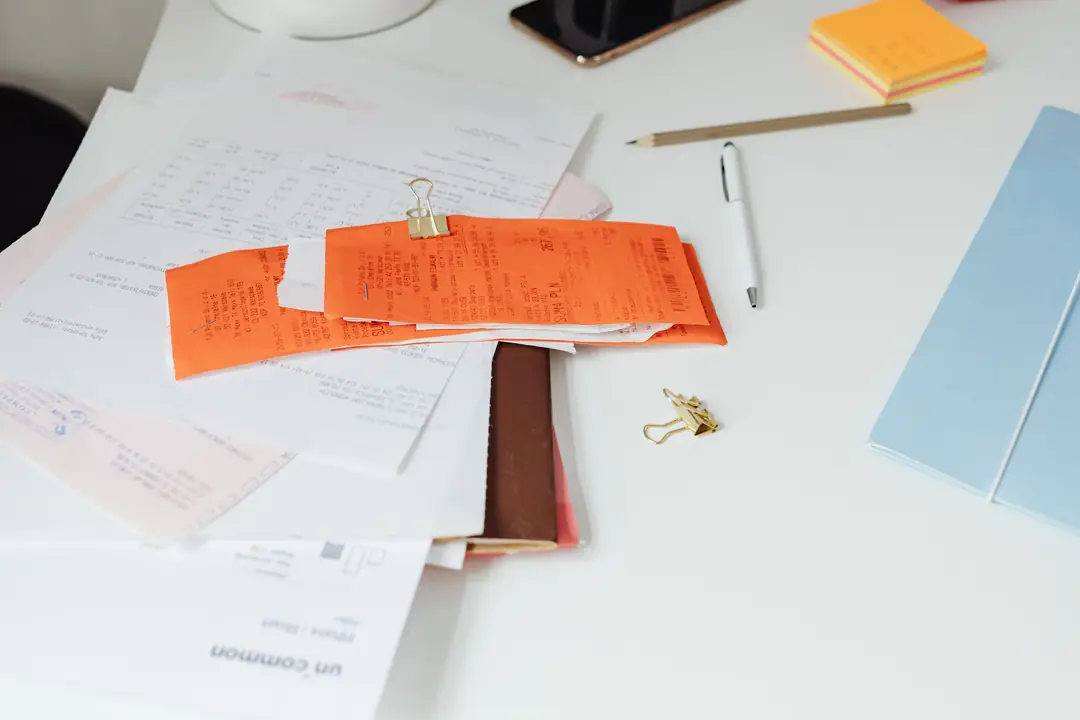 Receipts, invoices and a smartphone on a desk