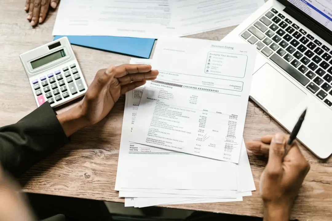 Calculator, factură și laptop pe birou, la întocmirea decontului de TVA