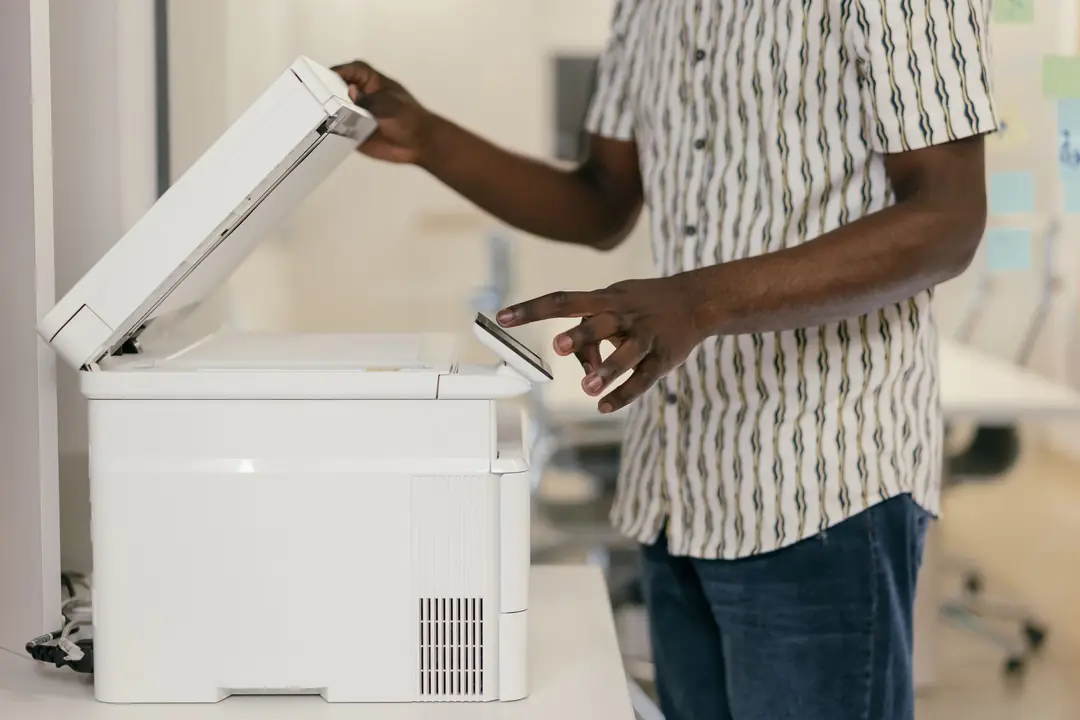 Person scanning documents to digitise them in an office