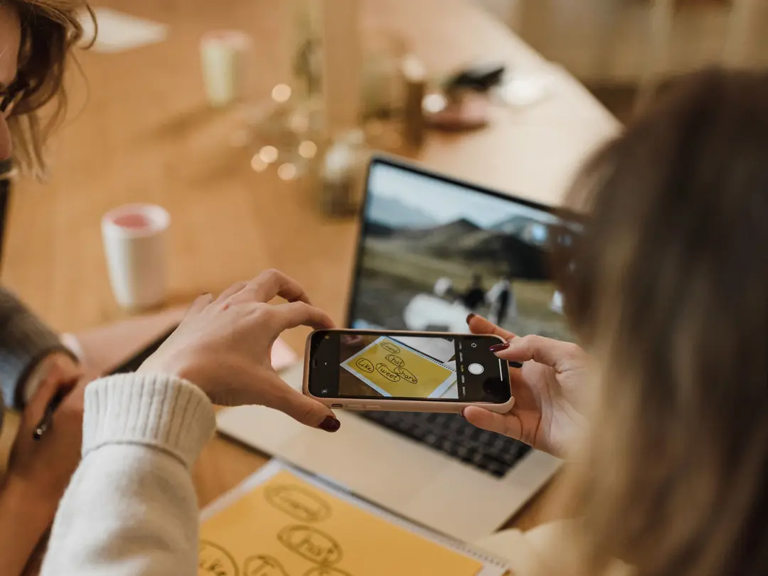 Frau fotografiert im Büro Notizen mit dem Smartphone