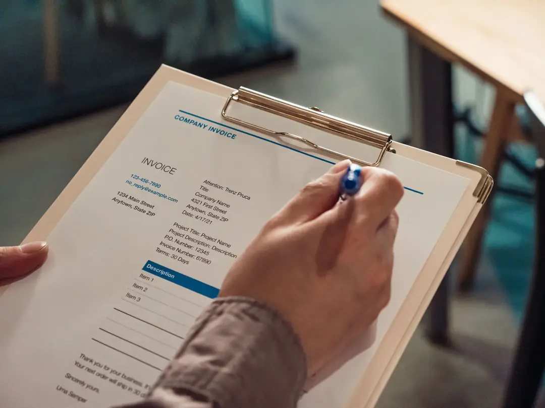 Invoice on a clipboard being checked and paid